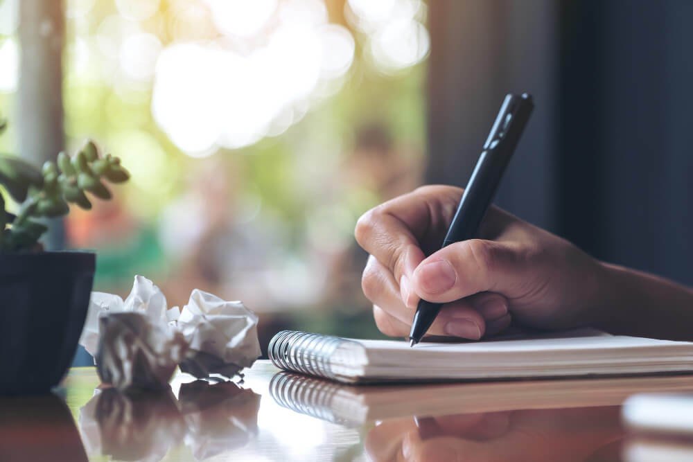 A scriptwriter writing a script for an animation film on his notebook.