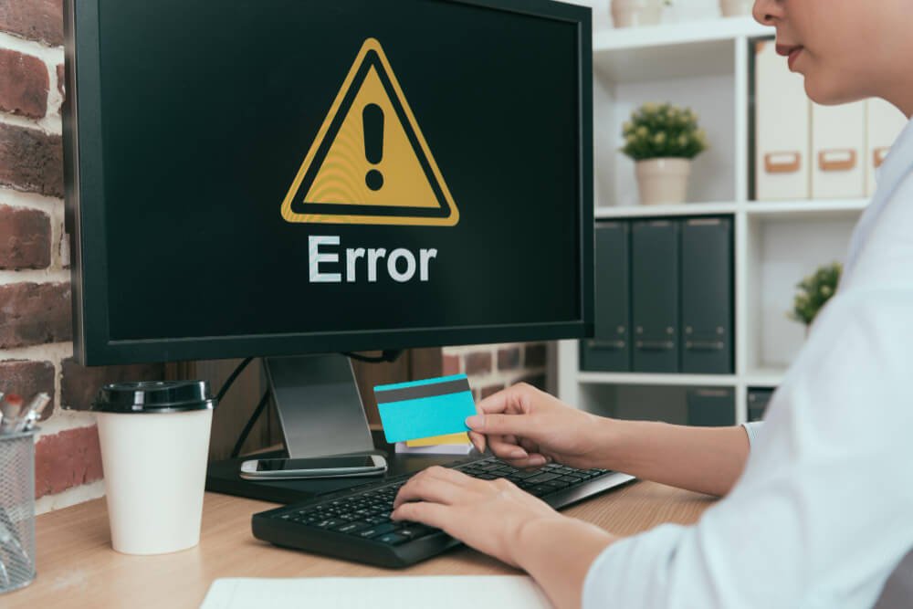 An animator working on his desktop with an error sign on it.